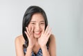 Attractive young asian woman announcing with hands to the mouth and telling a secret, isolated on light blue background. Royalty Free Stock Photo