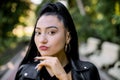 Attractive young Asian woman in black outfit, relaxing in the summer park outdoor. Close up face of charming dreamy Royalty Free Stock Photo