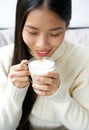 Attractive young asian woman drinking cup of coffee