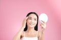 Attractive young Asian woman holding mirror and feeling happy about her skin.  on pink background Royalty Free Stock Photo