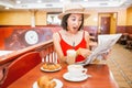 Young asian woman reading a newspaper during breakfast with coffee in cafe Royalty Free Stock Photo