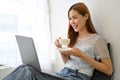 Attractive young Asian woman remote working at the cafe, sipping a coffee, using laptop Royalty Free Stock Photo