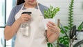 Attractive Young Asian woman taking care Water the household plants pots near window, Gardening at Home concept Royalty Free Stock Photo