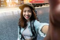 Attractive young Asian woman traveler with backpack taking a photo or selfie in train station. Travel lifestyle concept Royalty Free Stock Photo