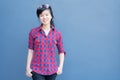 Attractive young asian woman wearing fashionable clothes and Sunglasses on hair posing on blue navy wall background