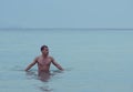 Attractive young athletic man in the sea or ocean showing naked muscular torso Royalty Free Stock Photo