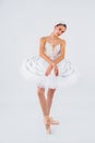 Attractive young ballerina with a beautiful body in leotard dancing tiptoes in photostudio isolated on white background. Showing Royalty Free Stock Photo