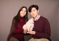 Attractive young biracial couple posing with white Pomeranian puppy Royalty Free Stock Photo