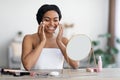 Attractive young black woman applying make up and smiling Royalty Free Stock Photo