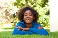 Attractive young black woman lying on grass laughing Royalty Free Stock Photo