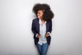 Attractive young black woman smiling with blazer against gray background Royalty Free Stock Photo