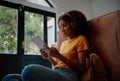 Attractive young black woman using a digital tablet while relaxing at home during corona virus lockdown Royalty Free Stock Photo