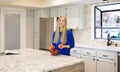 Attractive young blond-haired woman in the kitchen Royalty Free Stock Photo