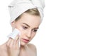 Attractive young blond woman with her hair wrapped in a towel, removing make up using soft face wipe. Royalty Free Stock Photo