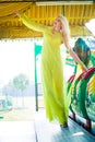 Attractive young blonde fashion woman in long elegant yellow dress in amusement park summer Royalty Free Stock Photo