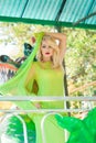 Attractive young blonde fashion woman in long elegant yellow dress in amusement park summer Royalty Free Stock Photo