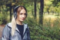 Attractive young blonde girl walking on park, listening to music Royalty Free Stock Photo