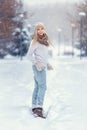 Attractive young blonde girl walking in winter forest. Pretty woman in wintertime outdoor. Wearing winter clothes. Knitted sweater Royalty Free Stock Photo