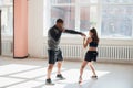 An attractive young boxer teaches his girlfriend boxing techniques in a loft equipped for boxing training Royalty Free Stock Photo