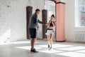 An attractive young boxer teaches his girlfriend boxing techniques in a loft equipped for boxing training Royalty Free Stock Photo