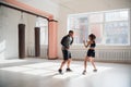 An attractive young boxer teaches his girlfriend boxing techniques in a loft equipped for boxing training Royalty Free Stock Photo