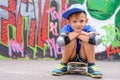 Attractive young boy sitting on his skateboard Royalty Free Stock Photo