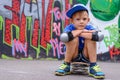 Attractive young boy sitting on his skateboard Royalty Free Stock Photo