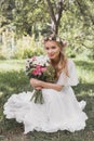 attractive young bride holding wedding bouquet and smiling at camera Royalty Free Stock Photo