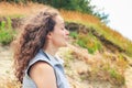 Attractive young brunette woman with curly magnificent hair laughing on the nature.