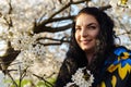 Attractive young brunette woman with long hair smiling in spring in blooming cherry blossom garden Royalty Free Stock Photo