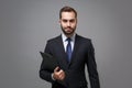 Attractive young business man in classic black suit shirt tie posing isolated on grey background. Achievement career Royalty Free Stock Photo