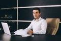 Attractive business man in smart casual wear sitting at his working place in office Royalty Free Stock Photo