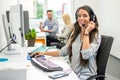 Attractive young business woman with headset working in call center. Royalty Free Stock Photo