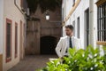 Attractive young businessman with beard, suit and tie, posing with hands in pockets behind green plants. Concept beauty, fashion, Royalty Free Stock Photo