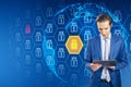 Attractive young businessman using tablet with creative globe with padlock pattern on blue background. Global data safety and