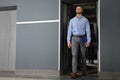Attractive young businessman walking out modern elevator Royalty Free Stock Photo