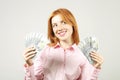 Attractive young businesswoman posing with bunch of USD cash in hands showing positive emotions and happy facial expression. Royalty Free Stock Photo