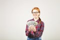 Attractive young businesswoman posing with bunch of USD cash in hands showing positive emotions and happy facial expression. Royalty Free Stock Photo