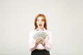 Attractive young businesswoman posing with bunch of USD cash in hands showing positive emotions and happy facial expression. Royalty Free Stock Photo