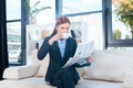 attractive young businesswoman reading newspaper and drinking coffee Royalty Free Stock Photo