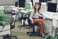 Attractive young businesswoman sitting at workplace and smiling