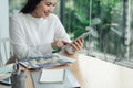 Attractive young businesswoman smiling while sitting alone at her desk in a modern office working online with a digital tablet Royalty Free Stock Photo