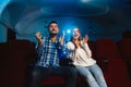 Attractive young caucasian couple watching a film at a movie theater