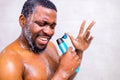 Attractive young cheerful man singing while washing in the shower, holding shampoo bottle like microphone Royalty Free Stock Photo