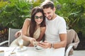 Attractive couple in the cafe, uisng smartphone