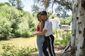 Attractive young couple dancing sensual bachata in an outdoor park, surrounded by trees, next to a river. Latin, sensual, Royalty Free Stock Photo