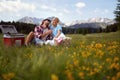 Attractive young couple having picnic in nature. Man giving dandelion flower to woman who is happy. Fun, togetherness, lifestyle, Royalty Free Stock Photo