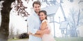 Composite image of attractive young couple hugging and smiling at camera Royalty Free Stock Photo