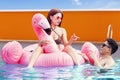 Attractive couple with inflatable flamingo at pool