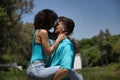 Attractive young couple in love, looking into each other`s eyes, close faces about to kiss, where he is holding her piggyback.